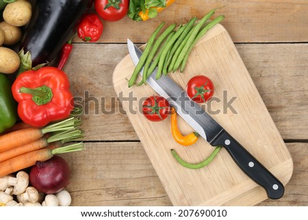 Preparing food smiling vegetables face on cutting board with knife