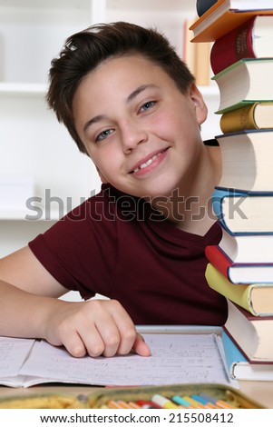 Young boy at school looking behind books