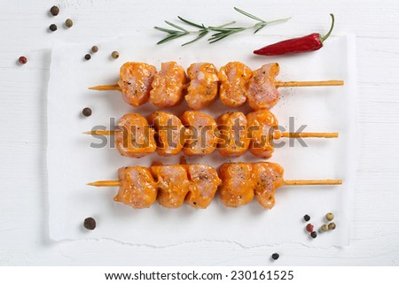 Raw chicken meat skewers meal from above on a wooden table
