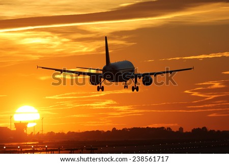 An airplane landing at an airport during sunset on vacation during a journey