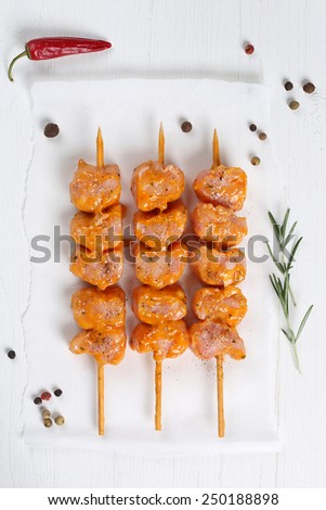 Raw chicken ot turkey meat skewers from above on a wooden table