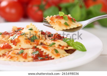 Eating Italian Pasta Ravioli with tomato sauce noodles meal with basil on a plate