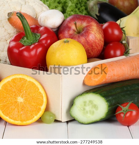 Fruits and vegetables like oranges, apple, tomatoes, banana in box
