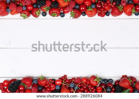 Berry fruits frame with strawberries, blueberries, red currants, cherries, raspberries and copyspace