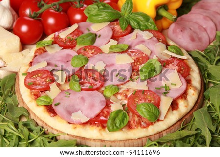 Pizza with ham, cheese, tomatoes and lettuce