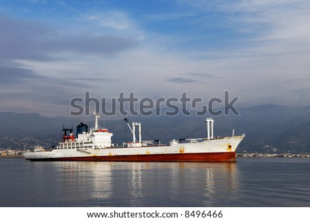 Image shows a white commercial ship photographed from the side