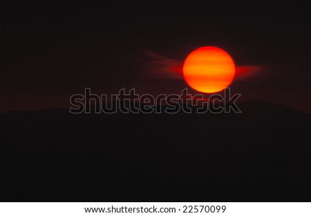 Picture of the sun as it sets over a mountain. Exposed so as to show as much detail as possible