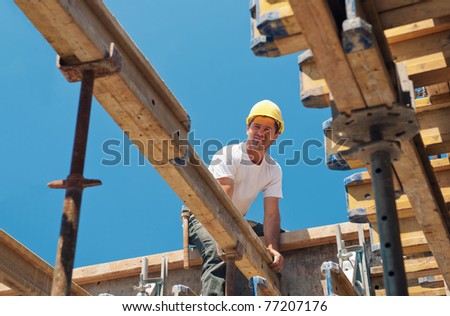Authentic construction worker placing slab form work beams in construction site