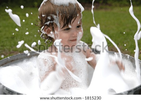 splashing boy in an old tub enjoying the afternoon
