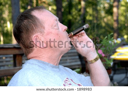 Ashes on a Cigar - A man smoking outdoors with a lot of ashes on his cigar