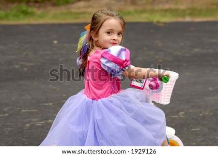 Tricycle Princess - A little girl dressed in a princess dress riding her tricycle