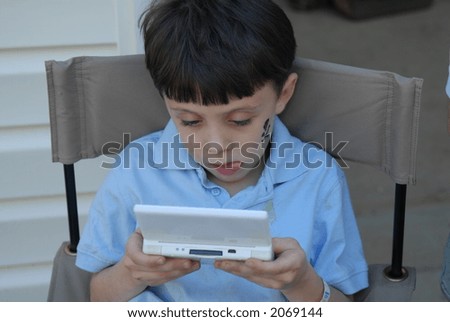 Game Playing - A young boy playing his electronic game intensely