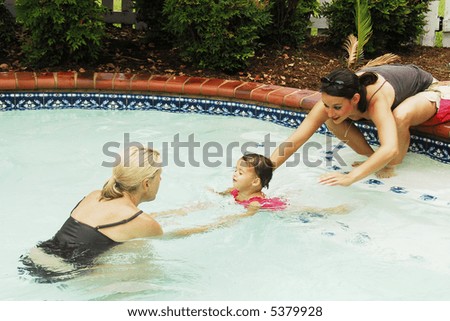 A baby girl at swimming lessons.