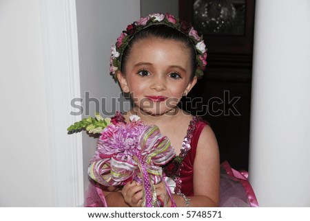 Beautiful little ballerina holding a bouquet presented to her for a job well done.