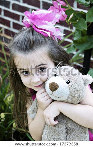 Beautiful Little Girl with her best friend, her teddy bear, in an outdoor setting.