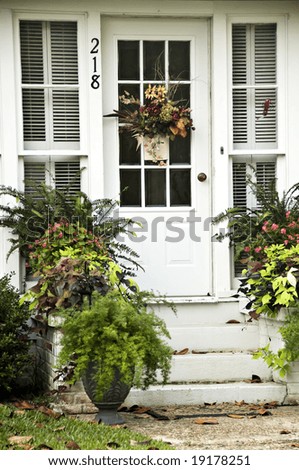 Decorative Fall Door surrounded by lush green plants