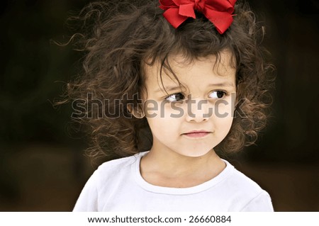  Beautiful little brown eyed brunette girl with curly hair and a red bow