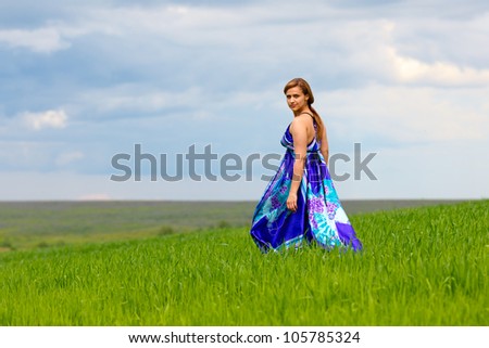 girl standing on the grass in a light blue dress from the fabric