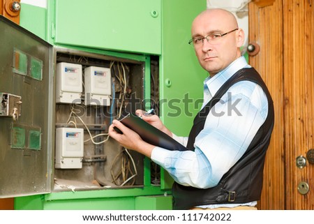 Electrician  at work inspecting cabling connection of high voltage power electric line in distribution fuseboard