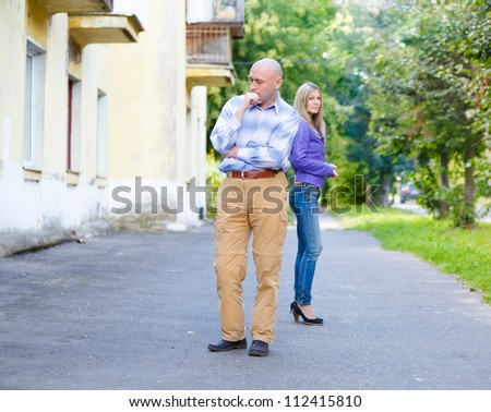 young couple woman man  quarreled background summer green street