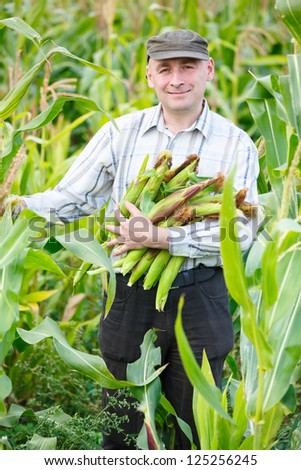 man with a crop of maize outdoors