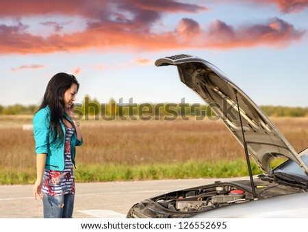 young brunette girl with   broken down car with   hood open call for help