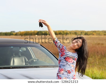 young woman with keys in hand, the car