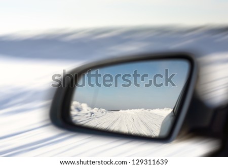 snowy road in the rearview mirror car motion