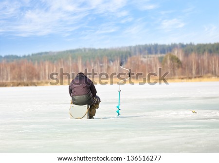 man fishing on the ice against the sky