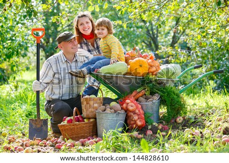 happy family in the garden with a crop of vegetables and fruit