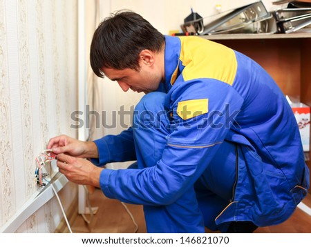 man electrician installs electrical network
