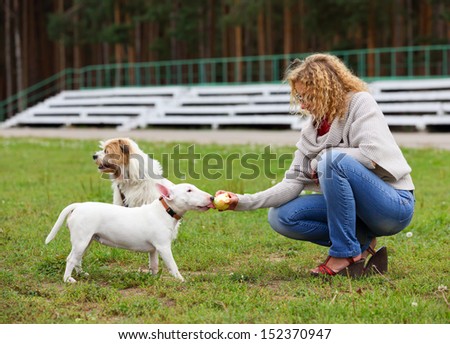 Women feed the dog apple outdoors