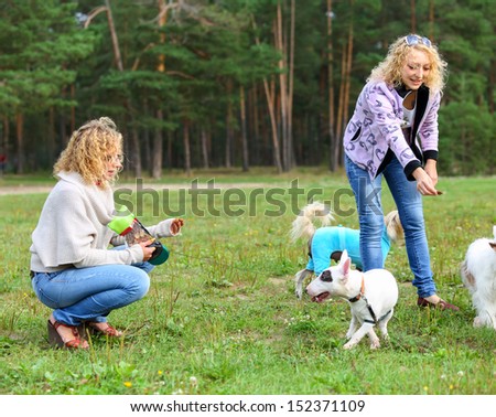 women with dogs at feeding time outdoors