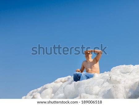 man looking at the top of an icy mountain against the sky