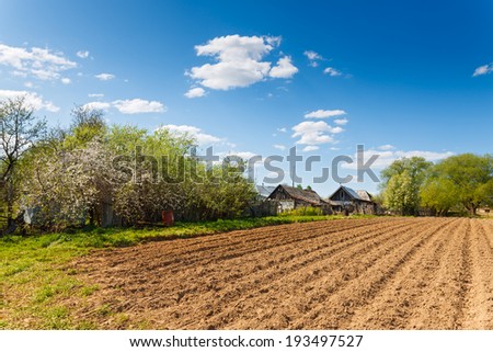 rural landscape plowed field on a background of rural houses