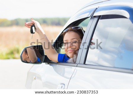 girl in a car holding keys in hand