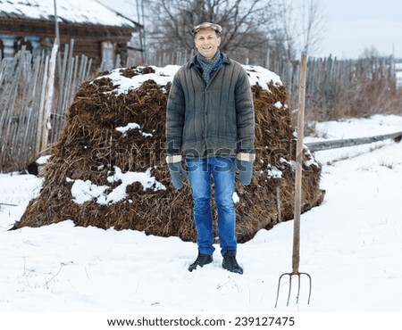 farmer in heap of fertilizer on a winter day