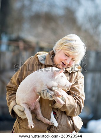 happy woman holding a newborn piglet,domestic animal breeding