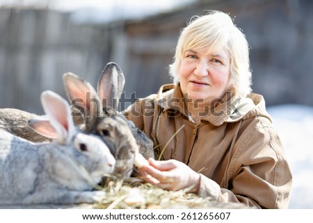 portrait of an elderly woman with a pet rabbit