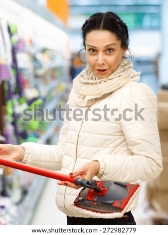perturbed woman in a store with a mop in hand. Beauty Woman in Shopping Mall. Shopper.