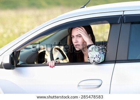 frightened  angry woman looking out  window of car