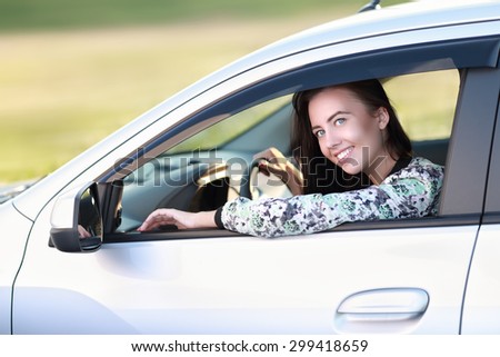 Young female driving happy about her new car or drivers license