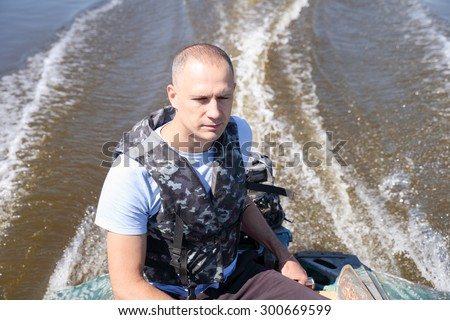man in army fatigues moved by motor boat