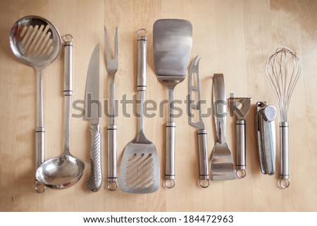 stainless steel kitchen tools  equipment on background of wooden table