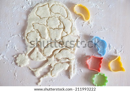 Thin dough on table with colorful plastic cake molds, raw cookies