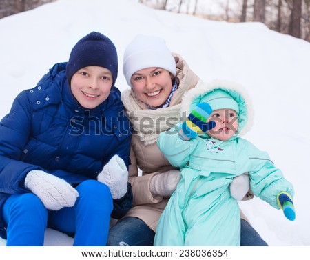 Happy cute family mother woman girl with baby boy kid  and teenager playing in park in winter
