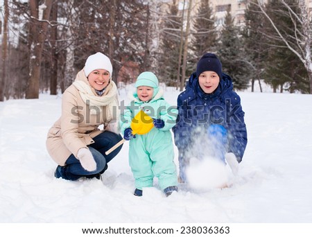 Happy cute family mother woman girl with baby boy kid  and teenager playing in park in winter