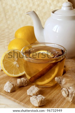 Cup of hot tea with a lemon and ginger on a table
