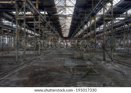 Abandoned old production hall with many plants and steel posts