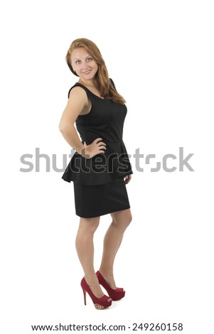 Pretty woman posing in a black dress and red heels against a white background